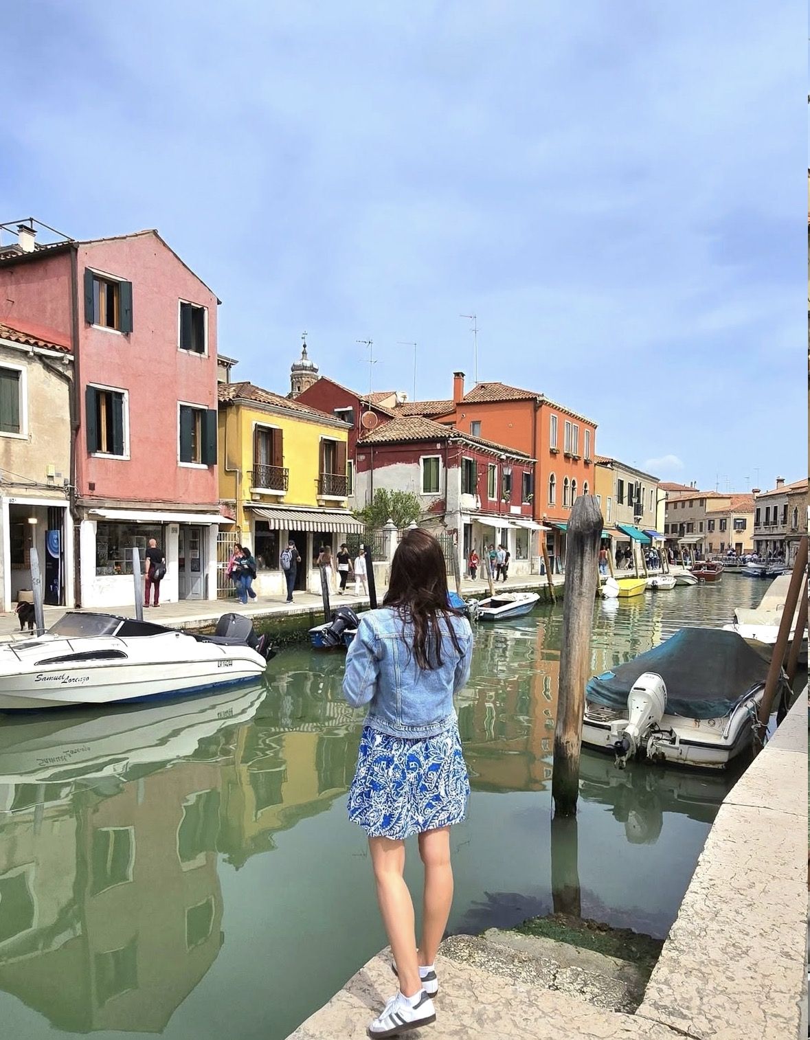 Safety signage and raised walkway platforms at a Venice lagoon vaporetto stop during acqua alta high water season